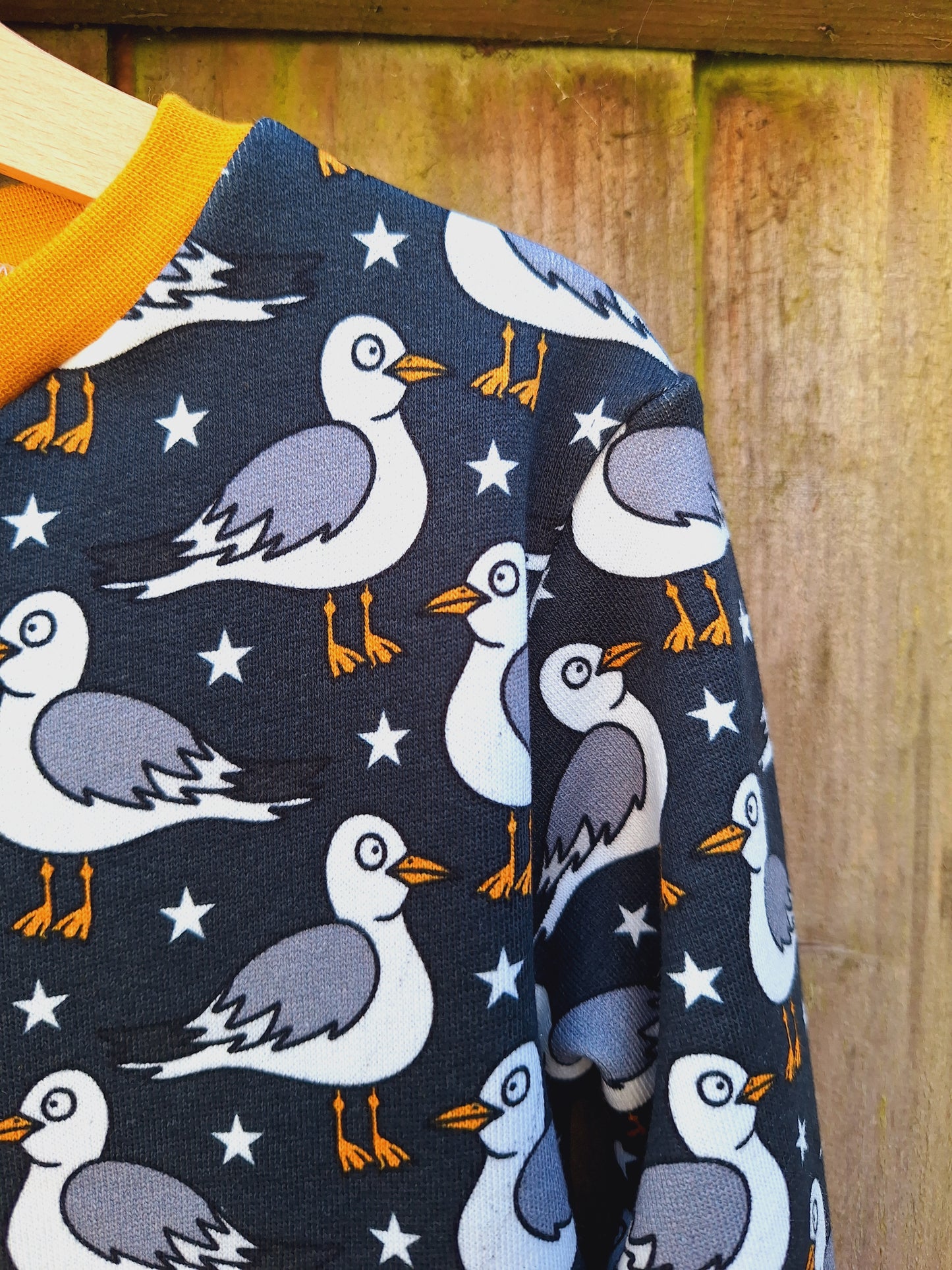 Handmade grey childrens jumper with seagull print. Finished with a mustard cuff and collar