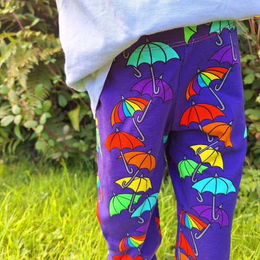 Purple childrens leggings with rainbow coloured umbrellas