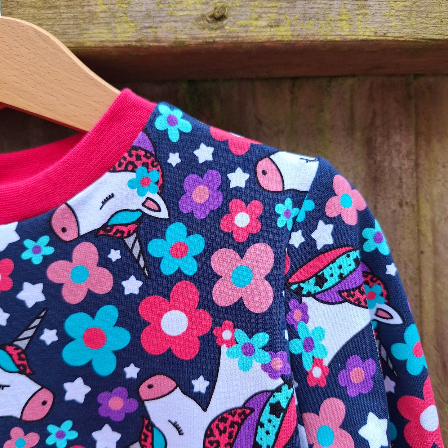 Navy blue childrens jumper featuring unicorns, flowers and leopard print