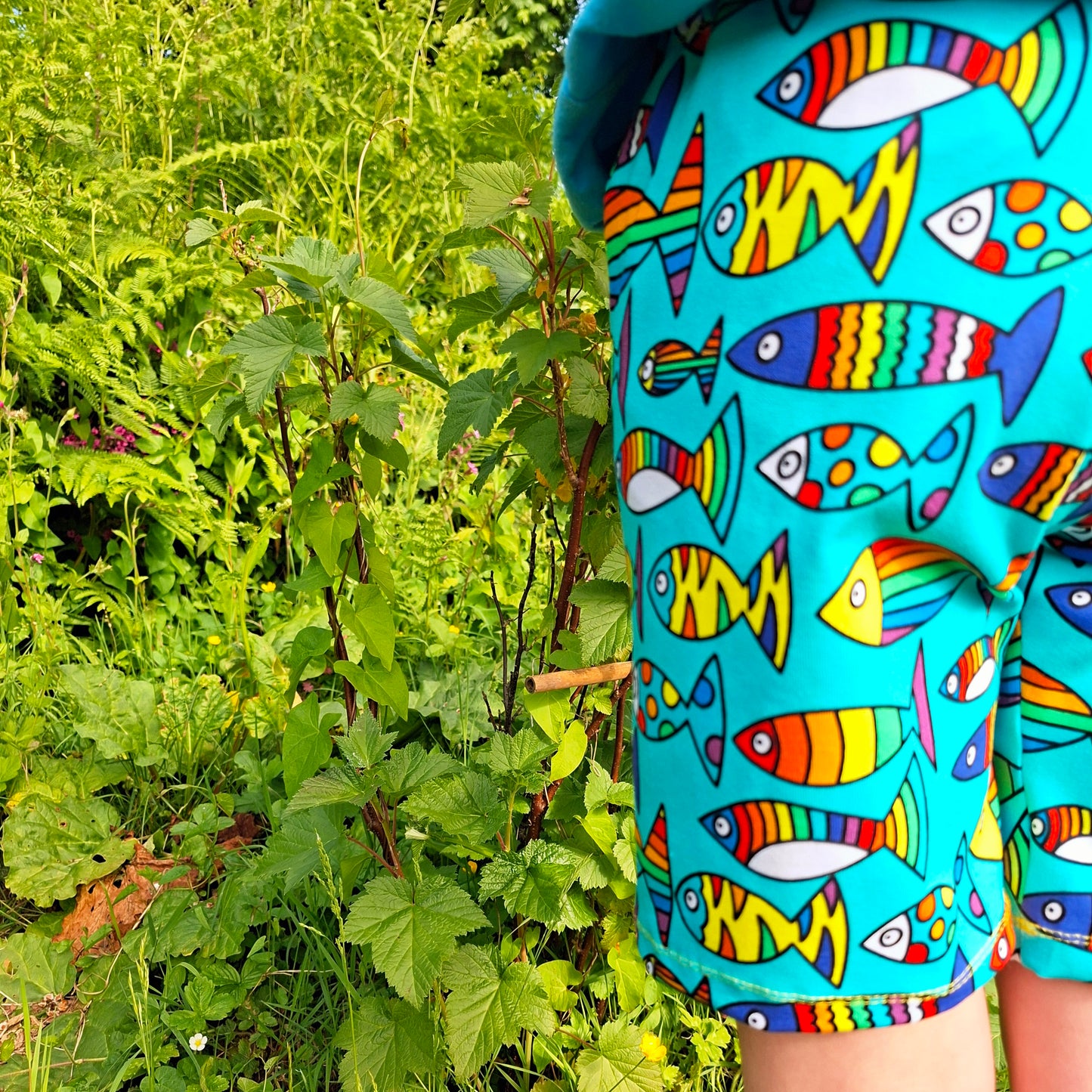 Children's knee length shorts in a bright rainbow mix of fish