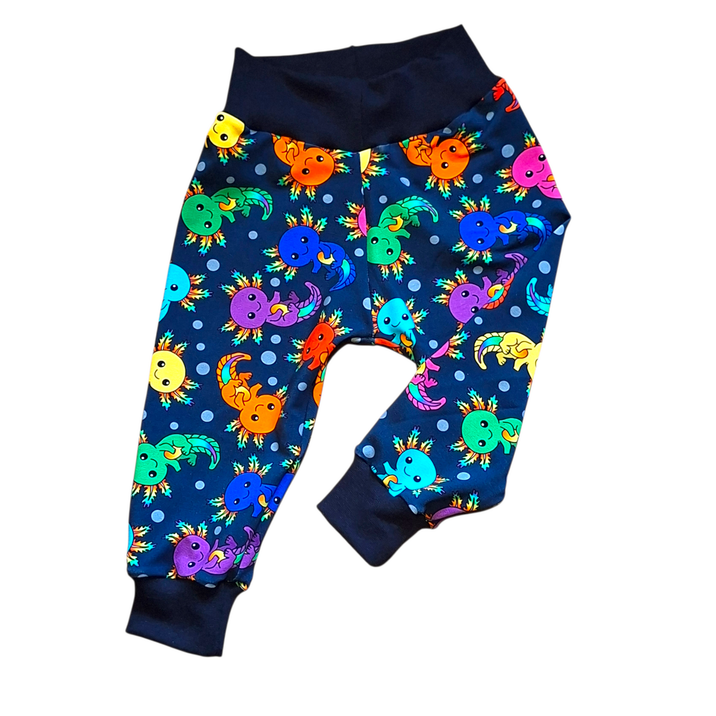 Colorful children's pants with cartoon axolotl pattern on a white background