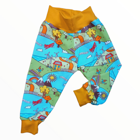 Cloth nappy friendly childrens trousers in an environment print with wind turbines, allotments and recycle trucks