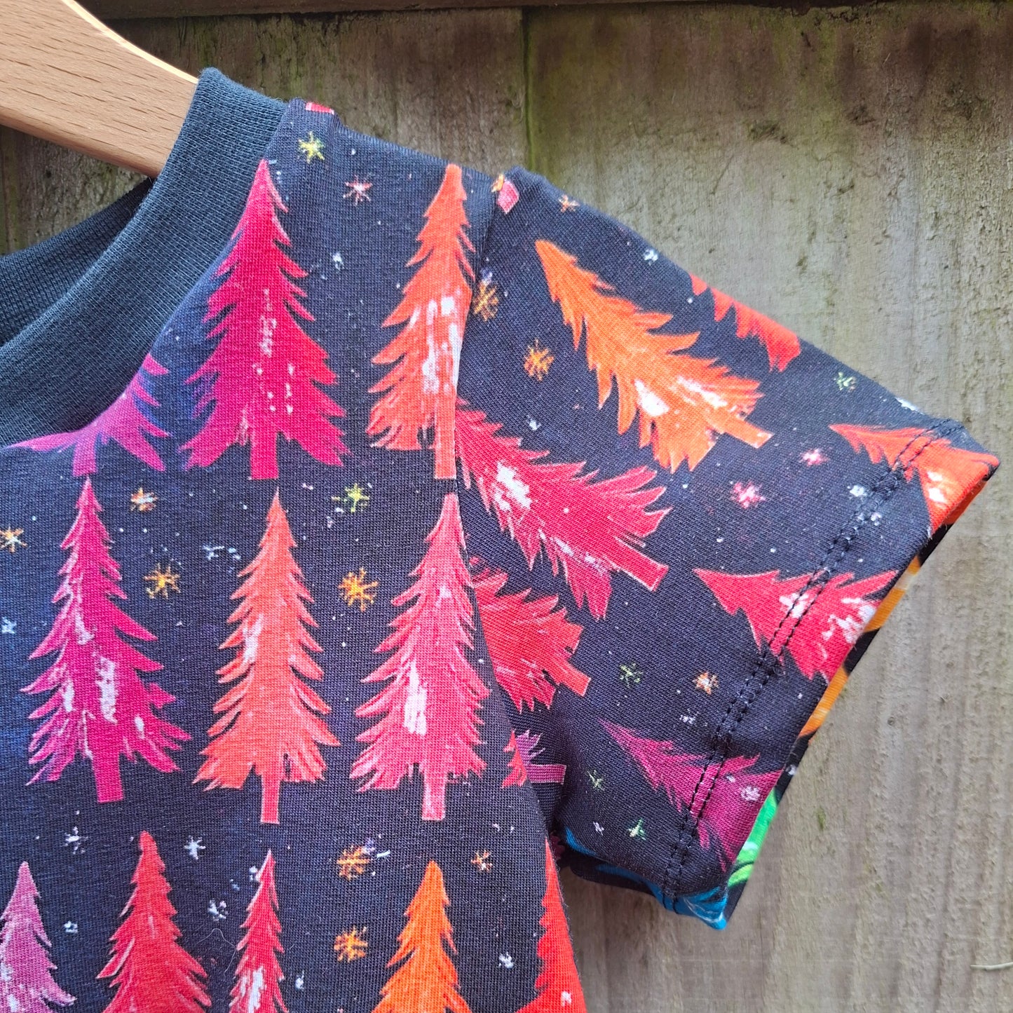 This is a short-sleeve dress with a multicolored Christmas tree print.
