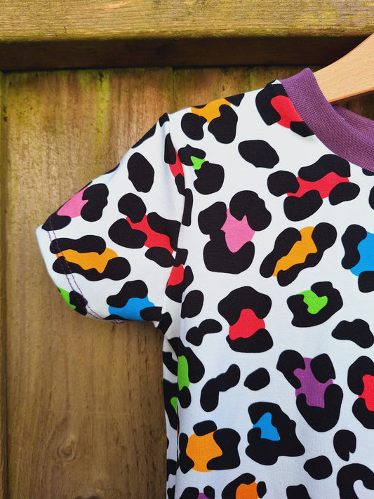 Childrens twirly swirly dressed with rainbow leopard print on a white background 