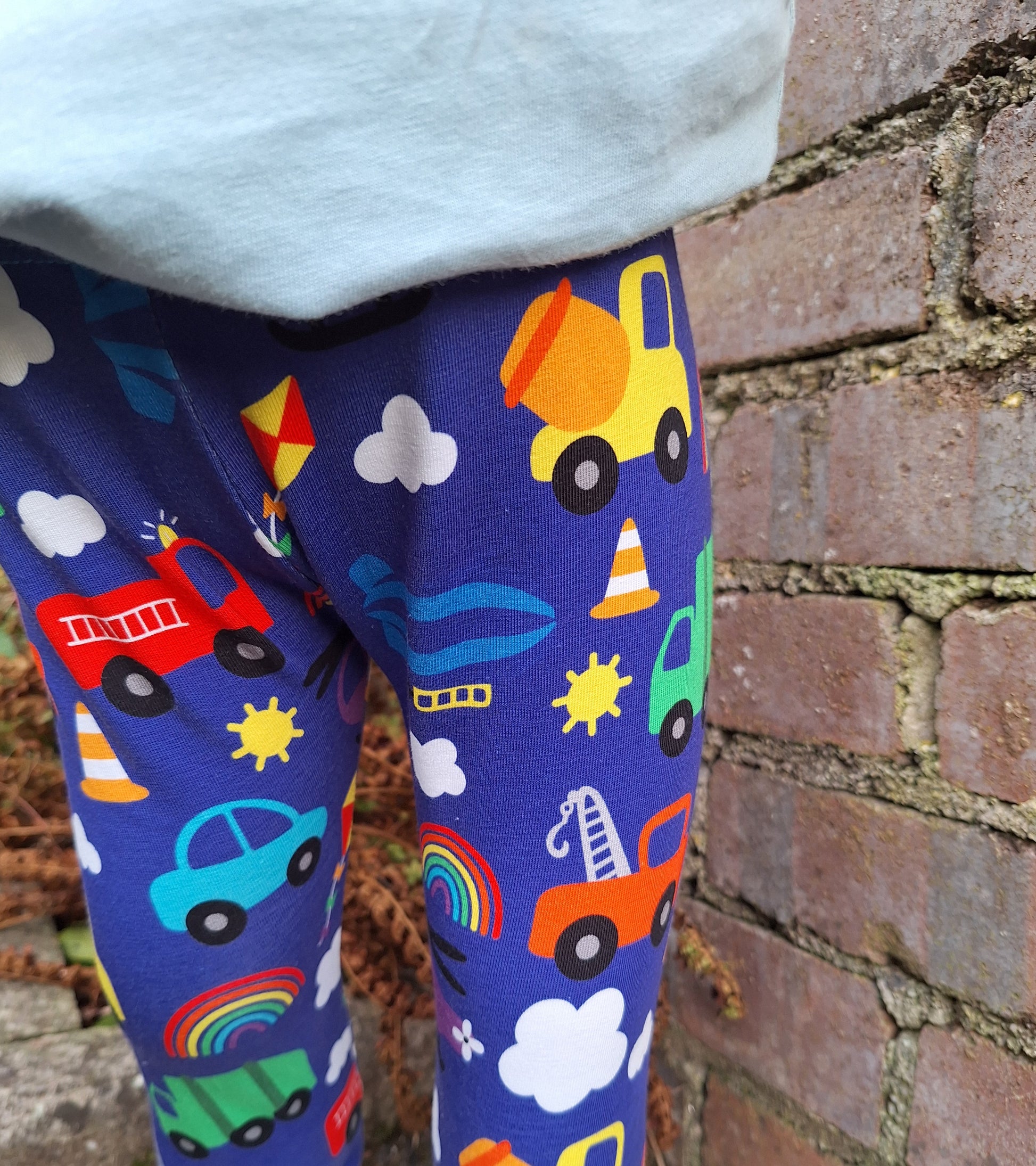 Colourful vehicle print childrens leggings on a blue background