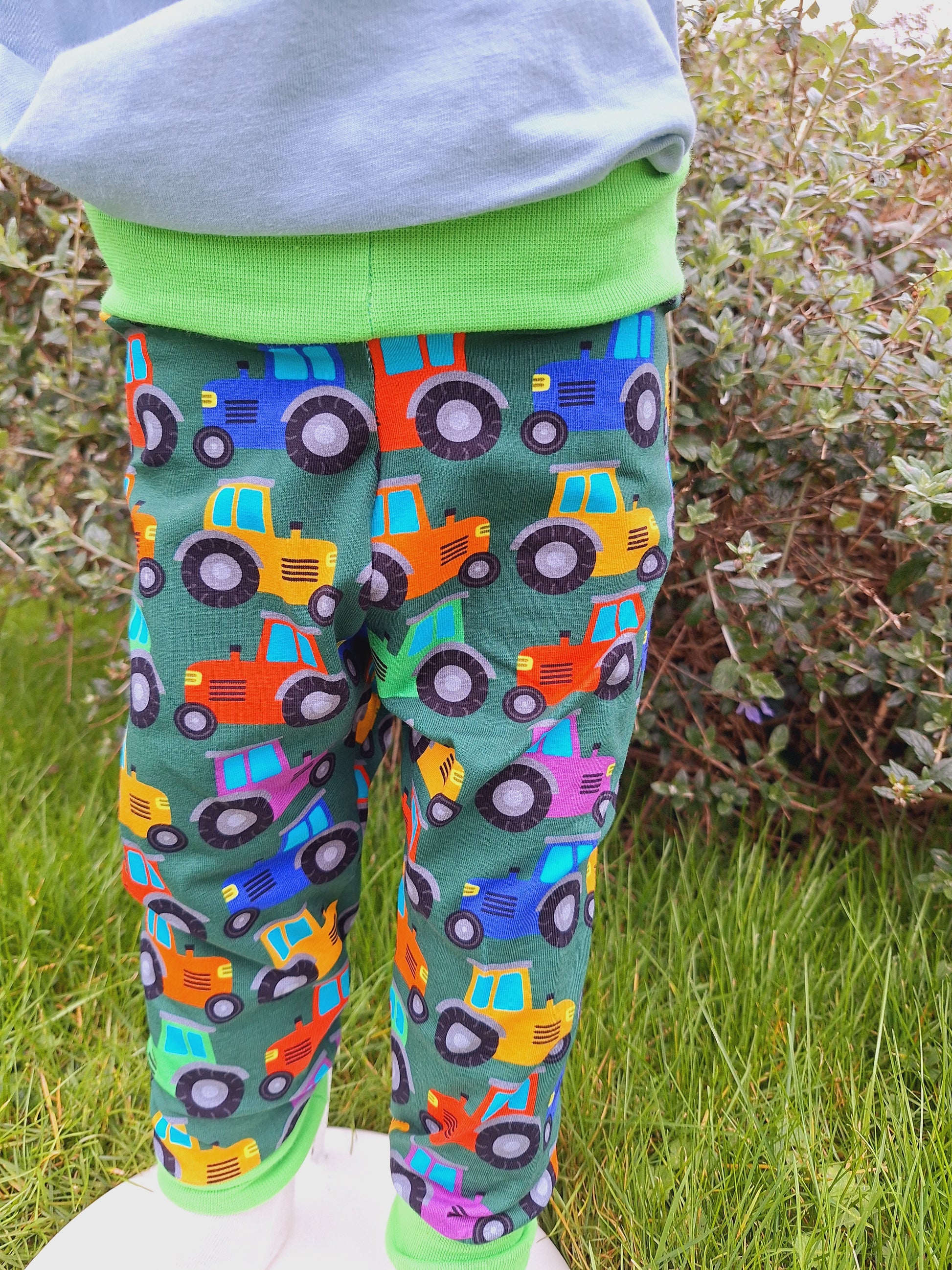 Cloth nappy friendly childrens trousers featuring rainbow tractors