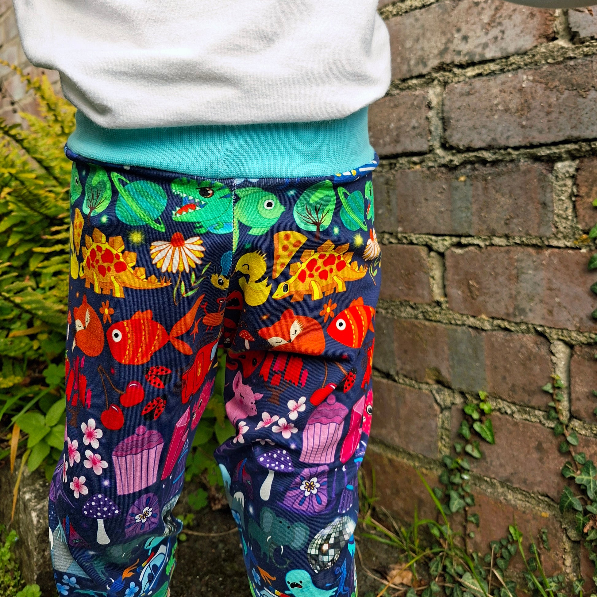 Colourful patterned leggings worn by a person against a brick wall.