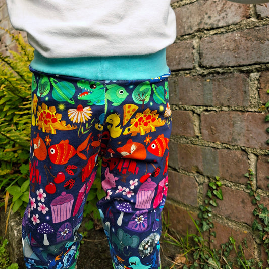 Colourful patterned leggings worn by a person against a brick wall.