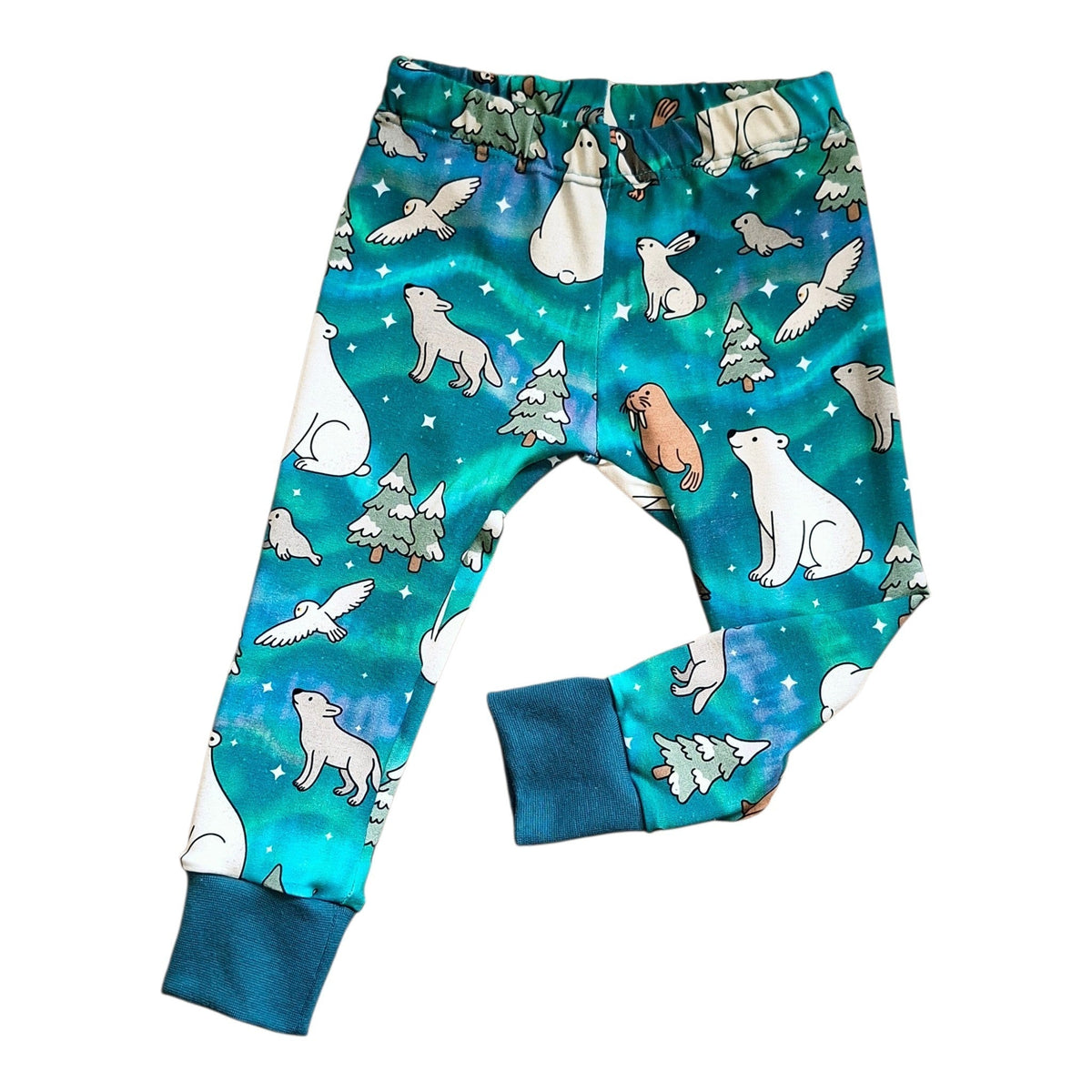 A pair of children's leggings with a vibrant teal and green space-themed print featuring cartoon polar bears, penguins, and snowy trees, finished with solid dark teal cuffs.