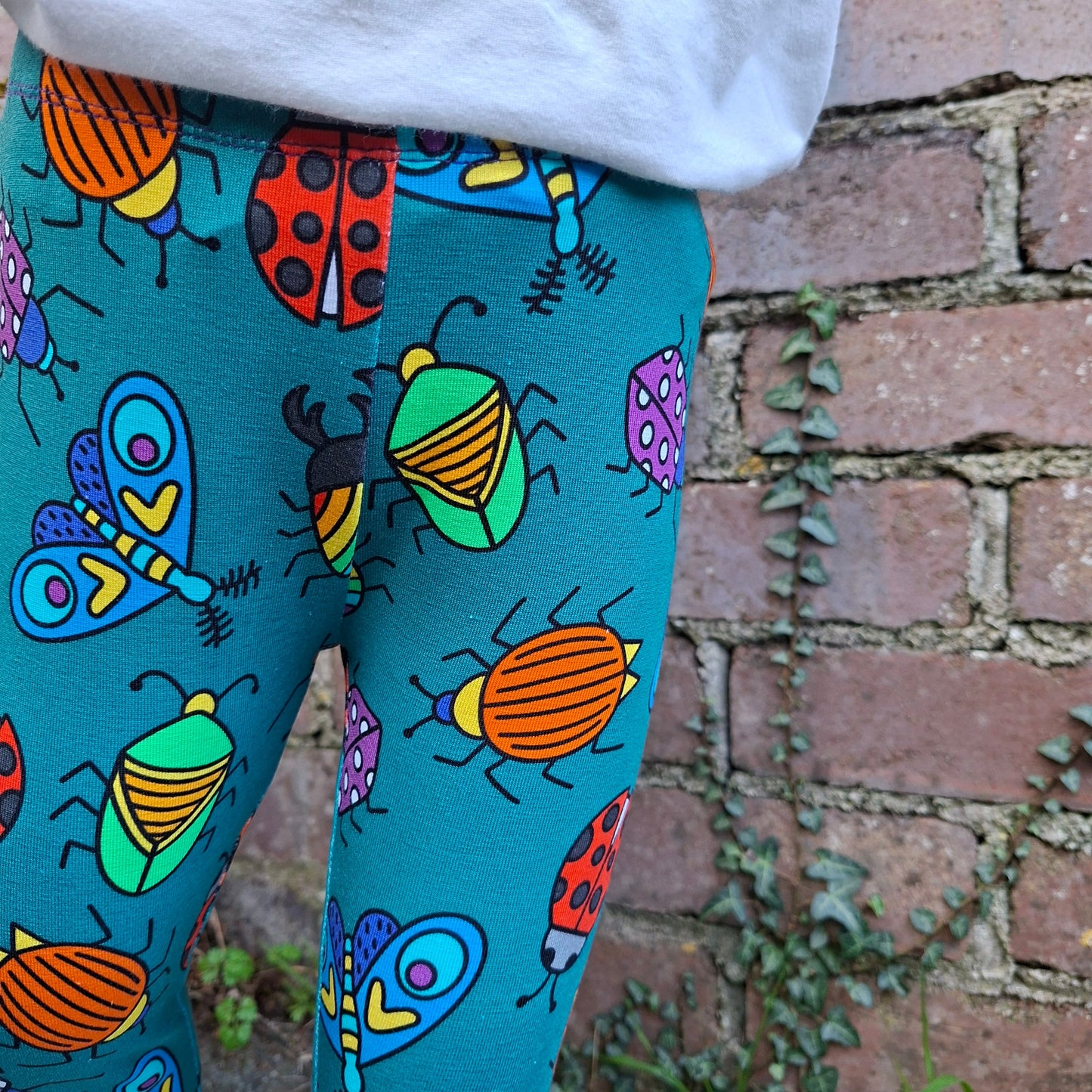 Colorful beetle -patterned fabric on a chair with a brick wall background