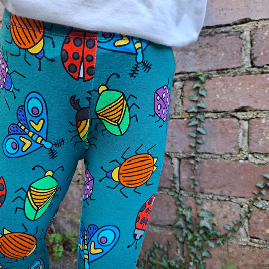 Colorful beetle -patterned fabric on a chair with a brick wall background