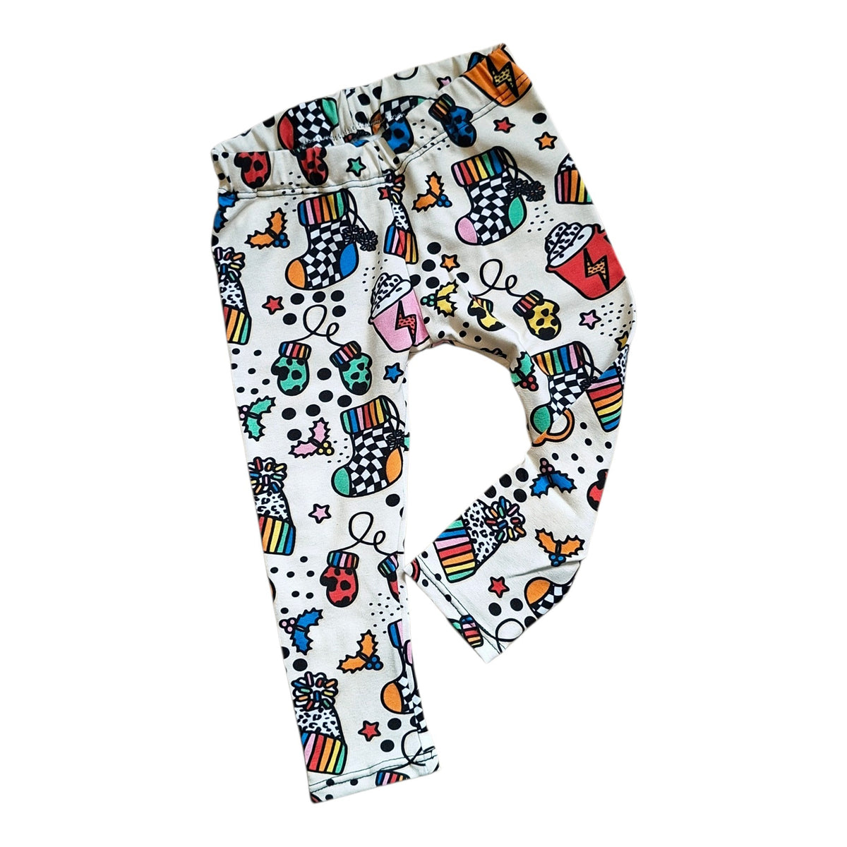 Cream children's leggings with a colorful pop-art style graffiti print featuring skulls, stars, lightning bolts, and musical instruments, shown flat on a white background.
