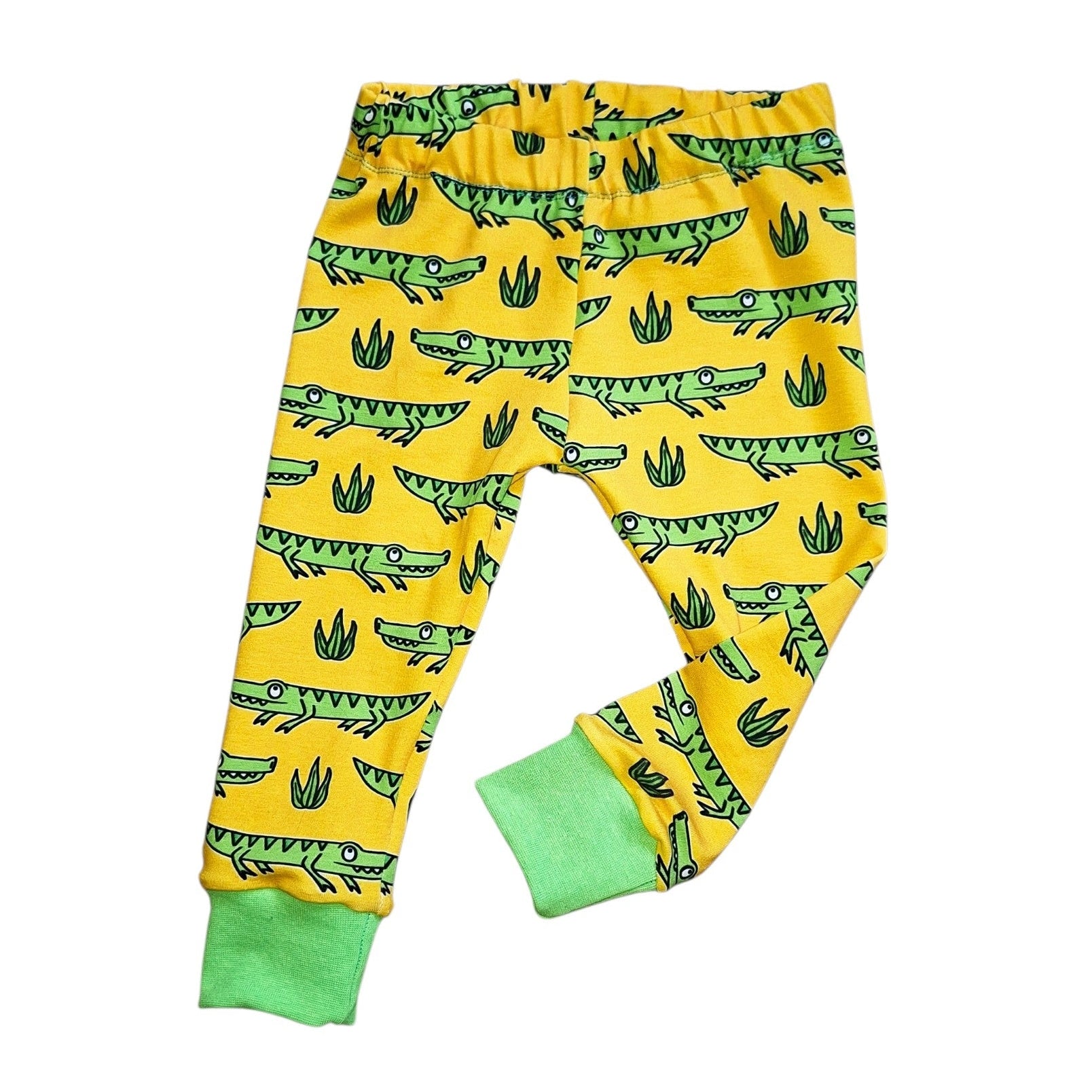 Yellow children's leggings with alligator pattern on a white background