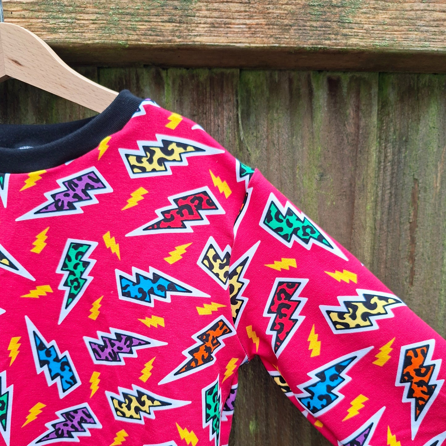 Leopard print lightning bolts on a pink children's jumper 
