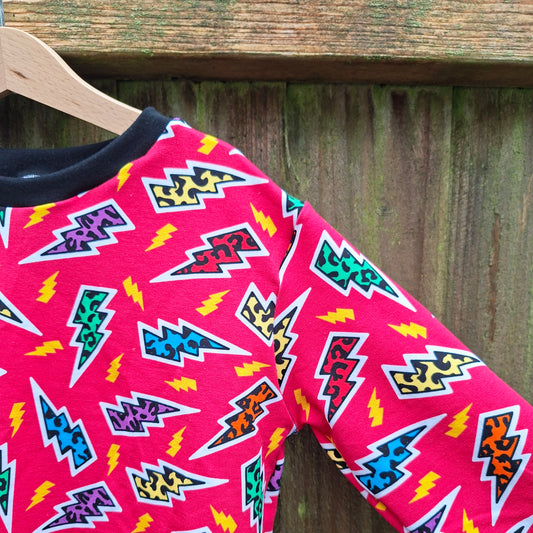 Leopard print lightning bolts on a pink children's jumper 