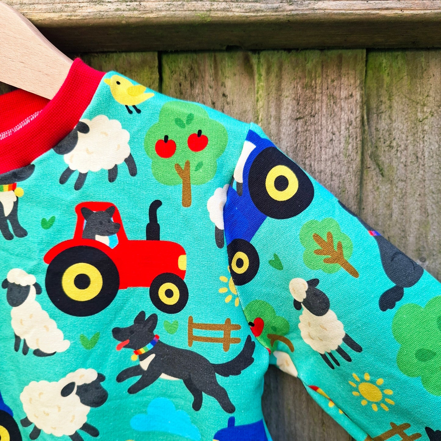 Children's jumper with farm animal pattern on a wooden background
