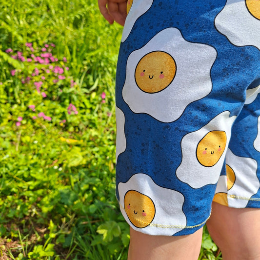 Child wearing a shirt with fried egg design outdoors