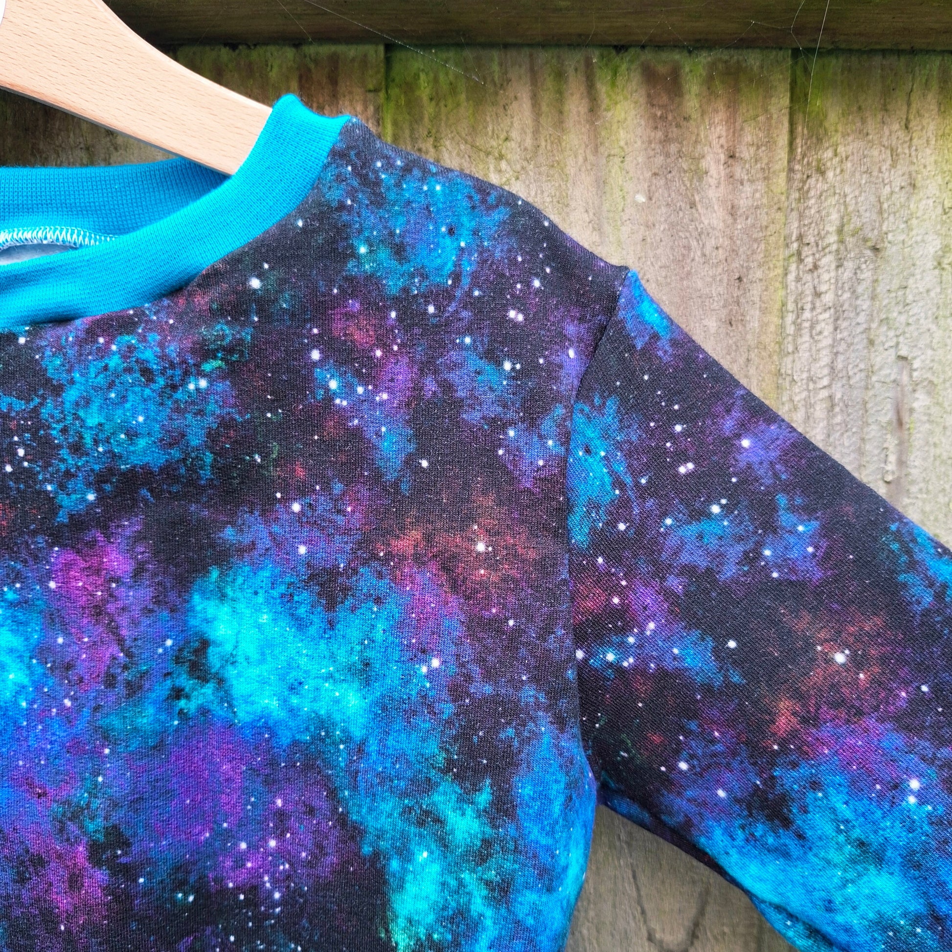 Gender free galaxy print children's jumper in shades of blue and purple 