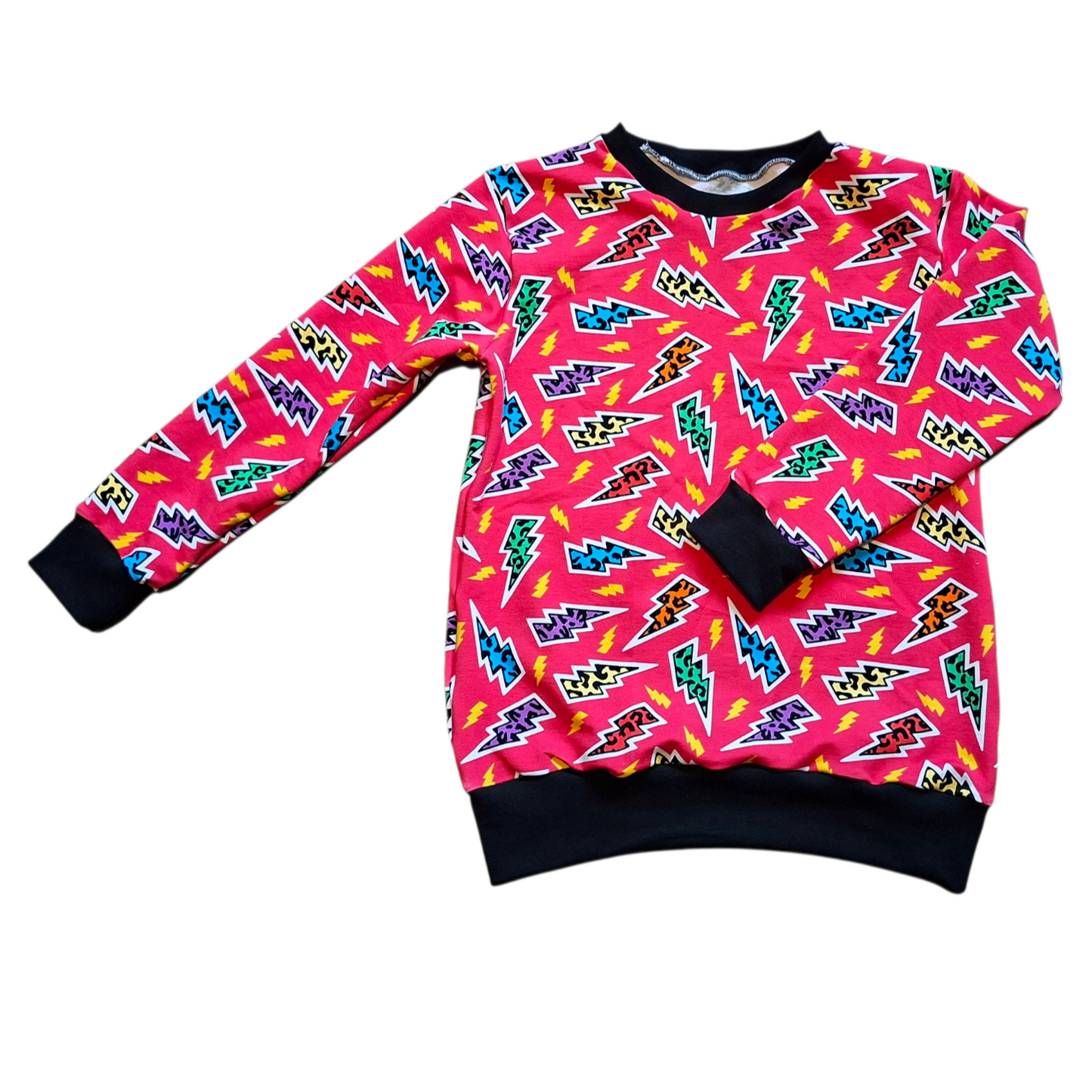 Children's jumper with a pink background and leopard print lightning bolts 