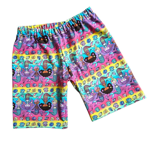 Colourful shorts with mermaid and sea-themed pattern on a white background