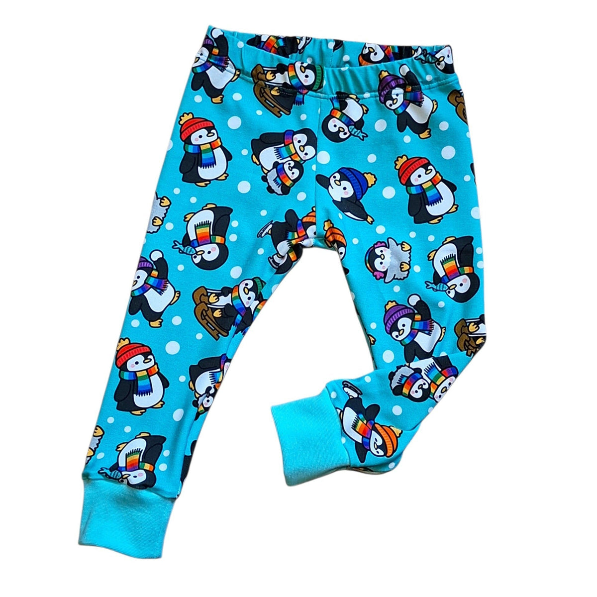 Blue children's pants with an all-over penguin print, featuring white polka dots and elastic waistband and cuffs.
