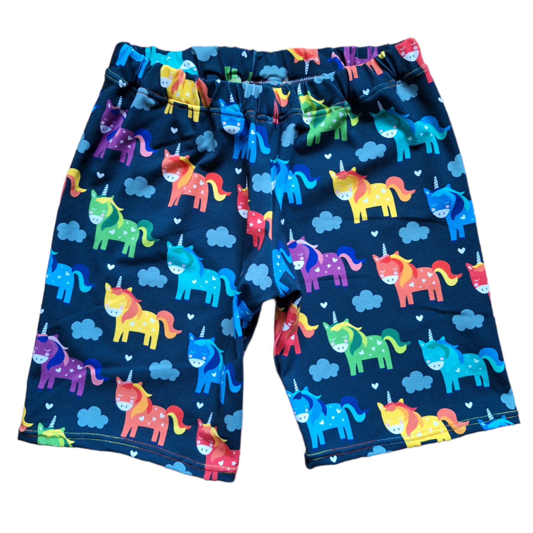 Unicorn print knee length childrens shorts, on a navy blue fabric with multicoloured cartoon style unicorns 