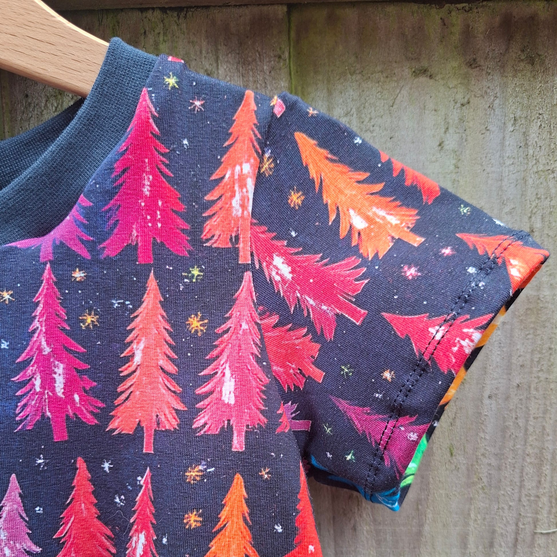 This is a short-sleeve dress with a multicolored Christmas tree print.