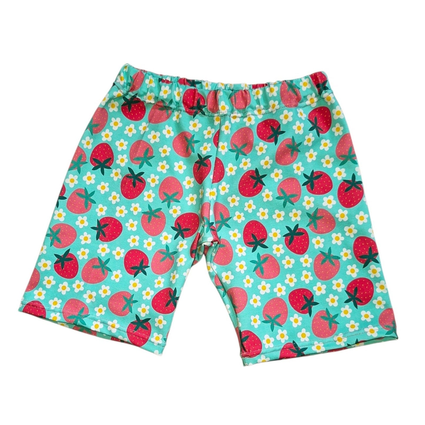 A pair of kids' shorts featuring a colorful pattern of red strawberries and small white daisies on a light teal background, laid flat against a white background.