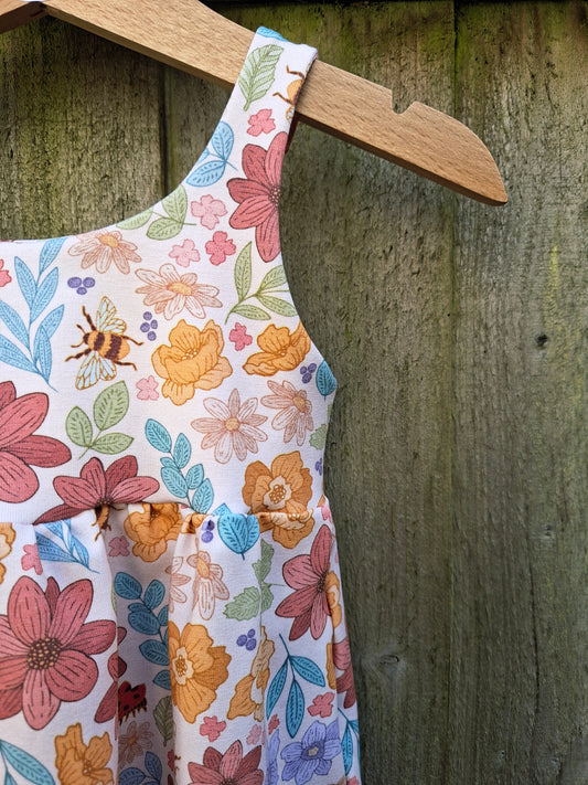 Children's romper in a pastel mix of leaves and flowers