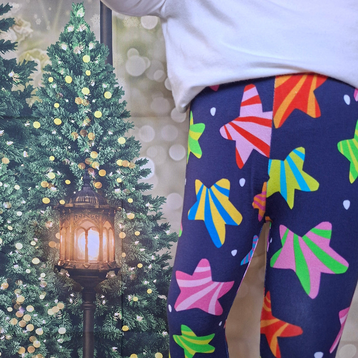 Child wearing navy leggings with bright striped star print